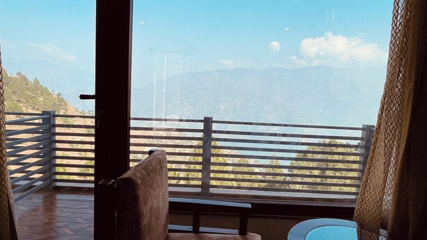 Ein Balkon mit Blick auf eine gebirgige Landschaft.
