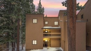 A multi-story building with a brick facade, a central entrance, and a small balcony on the second floor.