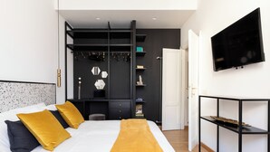 A modern bedroom with a bed, a TV, and a black wardrobe. - Charming Home near San Giovanni (Rome)