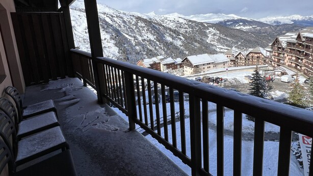 A balcony with a view of a snow-covered mountain range and a ski resort in the background. - VALMEINIER : Beautiful apartment in the heart of Valmeinier 1900, 8 people (Valmeinier)