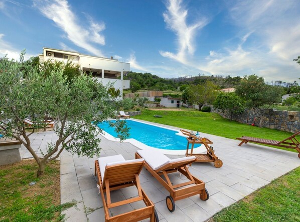A modern house with a swimming pool, wooden lounge chairs, and a well-maintained garden. - Serene Rural Villa With Pool, Sun Deck, and Children's Play Area (Omis)