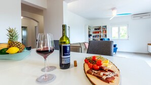 A dining table with a bottle of wine, glasses, and a charcuterie board. - Serene Rural Villa With Pool, Sun Deck, and Children's Play Area (Omis)