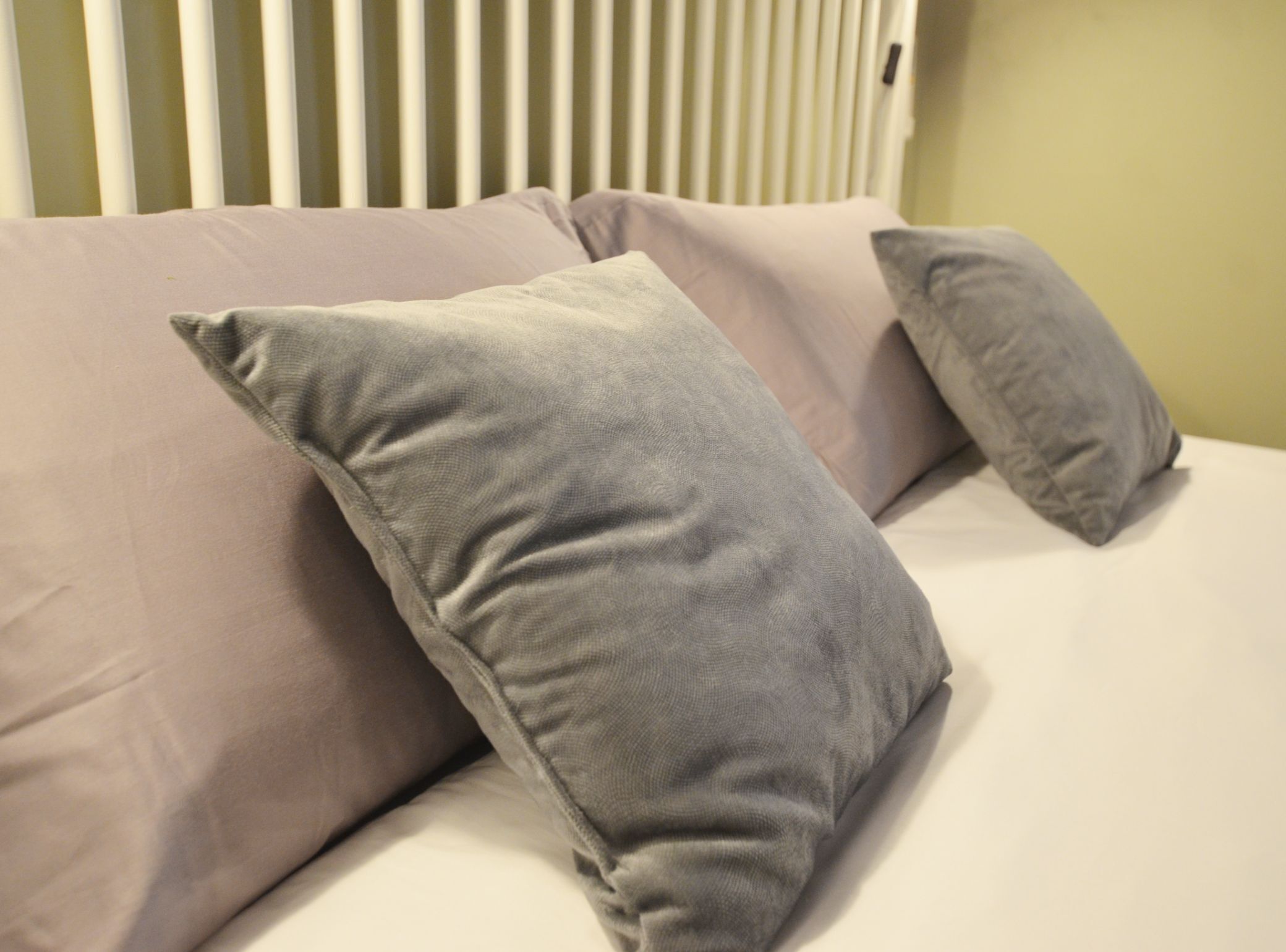 A bed with two pillows and a white headboard.