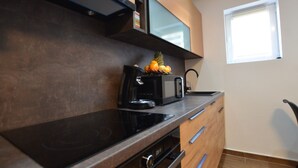 Una cocina compacta con microondas, tostadora y un frutero en la encimera.