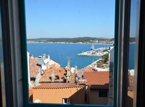 A coastal town with terracotta-roofed buildings, a marina, and a clear blue sea. - Sea View Downtown Rovinj Apartment (Rovinj)