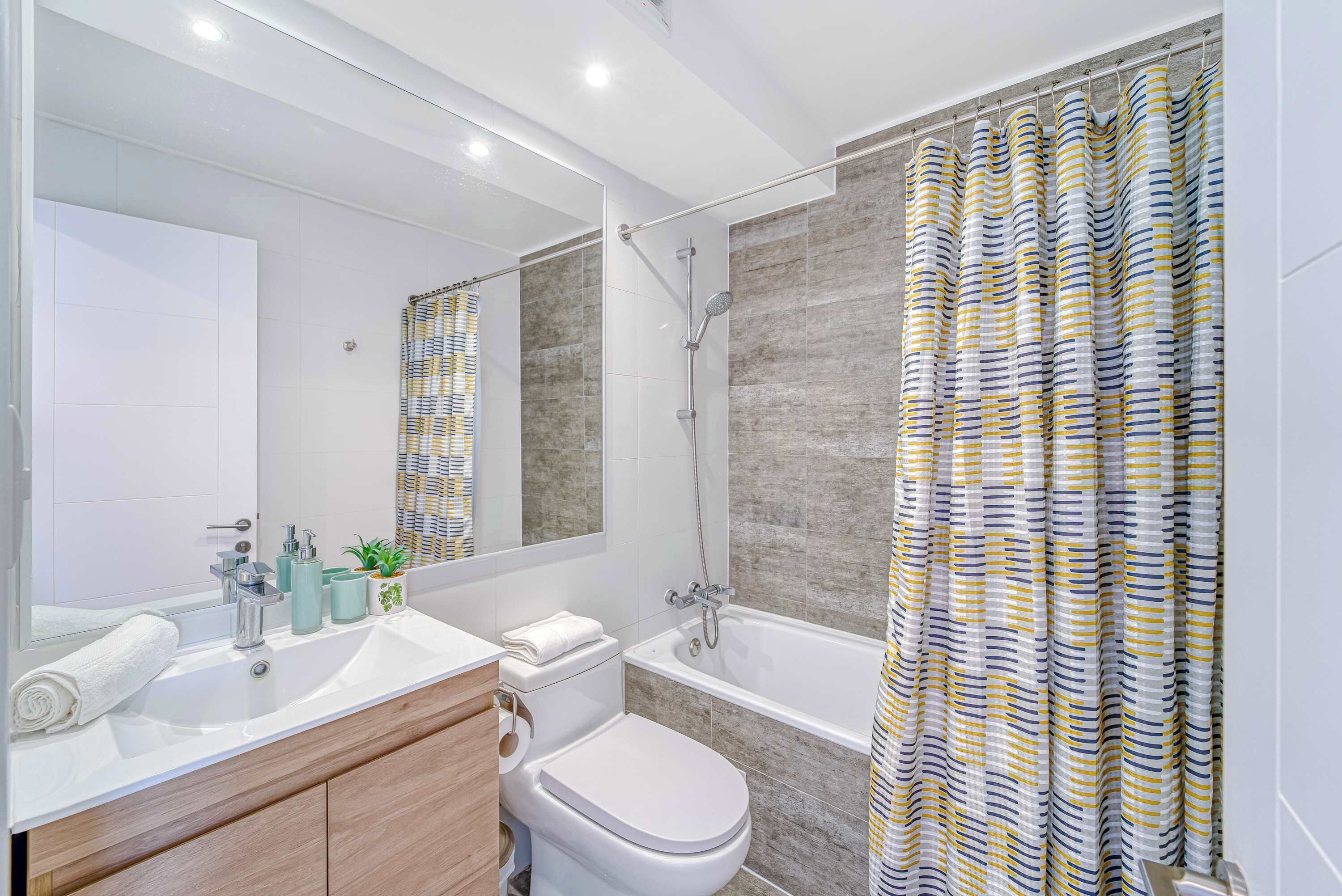 A modern bathroom with a shower, toilet, and sink.