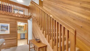 A wooden staircase with a view of a kitchen and a dining area. - Recently updated, great location, private hot tub! (Sunriver)