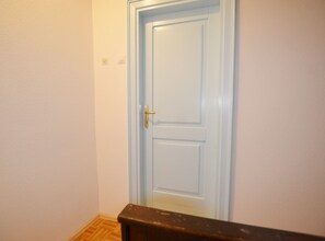 A closed white door with a gold handle, a light switch, and a power outlet on the wall. - Sunny Rovinj Apartment With Sea View (Rovinj)
