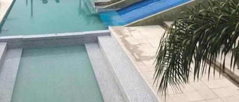 Una piscina al aire libre de temporada, tumbonas