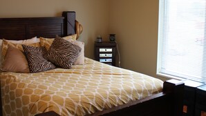 A bedroom with a bed, a nightstand, and a window. - Cozy 2-bedroom condo in Waterloo south side with AC, WiFi & cable TV (Waterloo)