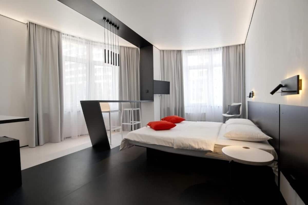 Een moderne hotelkamer met een groot bed, een bureau en een aan de muur bevestigde televisie.