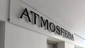 A hallway with a sign reading "ATMOSFERA" above a door.
