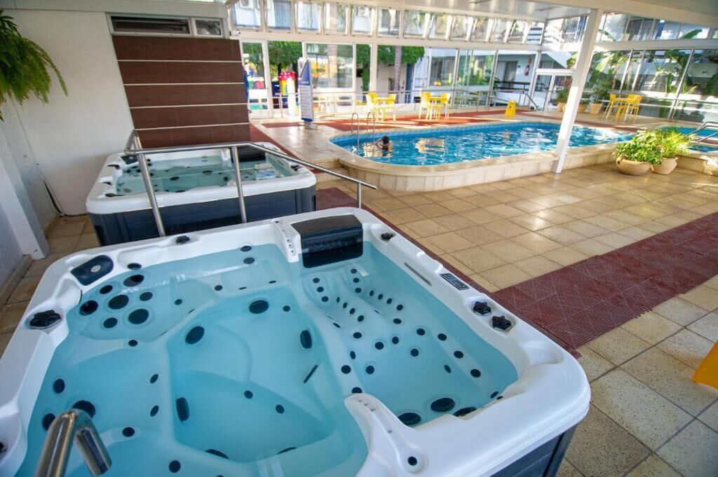 A hotel pool area with a hot tub and a swimming pool.