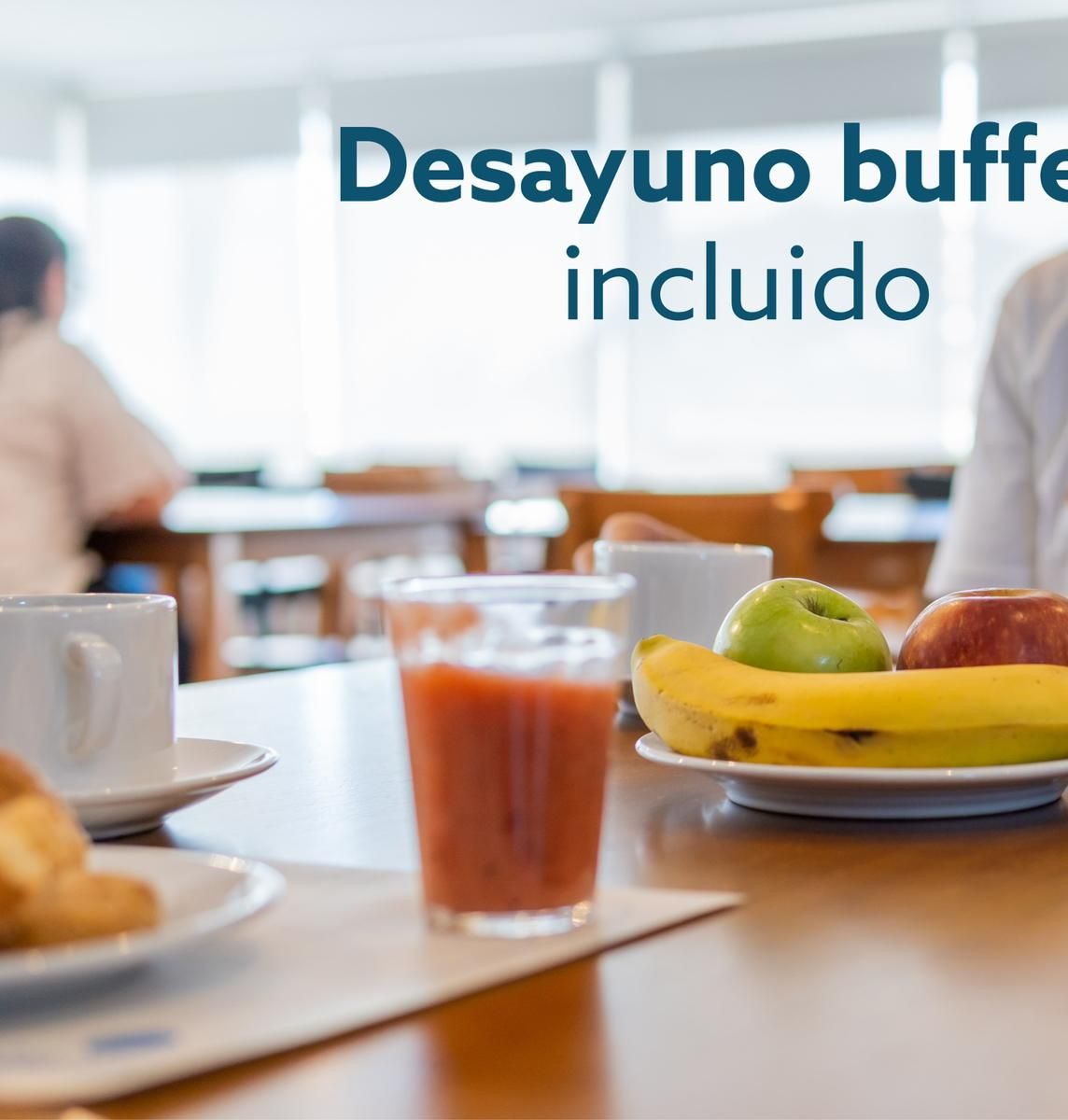 Ein Frühstücksbuffet mit einer Fruchtschale, einem Glas Saft und einem Serviettenhalter.