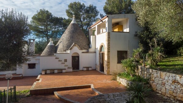 Une villa dotée d’une cour intérieure, de murs en pierre et d’un toit recouvert de tuiles.