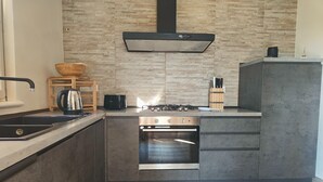 A modern kitchen with a built-in oven, a gas stove, and a stainless steel sink. - Holiday home for 5 Lido di Camaiore (Lido di Camaiore)