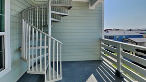 A spiral staircase on a balcony with light-colored siding and a dark floor. - Port A Retreat w/ Rooftop Balcony + Community Pool! (Port Aransas)