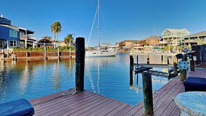 A marina with a dock, a sailboat, and residential buildings along the water. - Pirate's Paradise | Waterfront & Private Pool (Rockport)