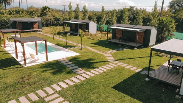 Een modern buitengebied met een zwembad, ligstoelen en een overdekt terras.