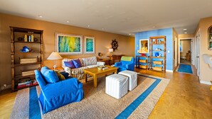 A living room with a blue sofa, a wooden coffee table, and a bookshelf.