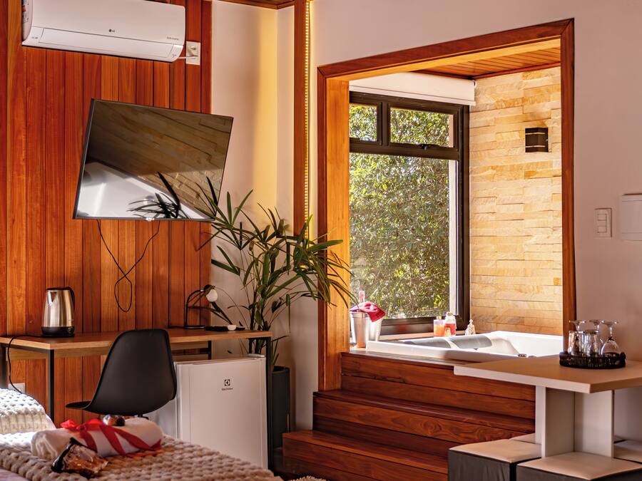 Une salle de bain moderne avec un meuble-lavabo en bois, un grand miroir, un lavabo et une fenêtre donnant sur un mur en pierre.