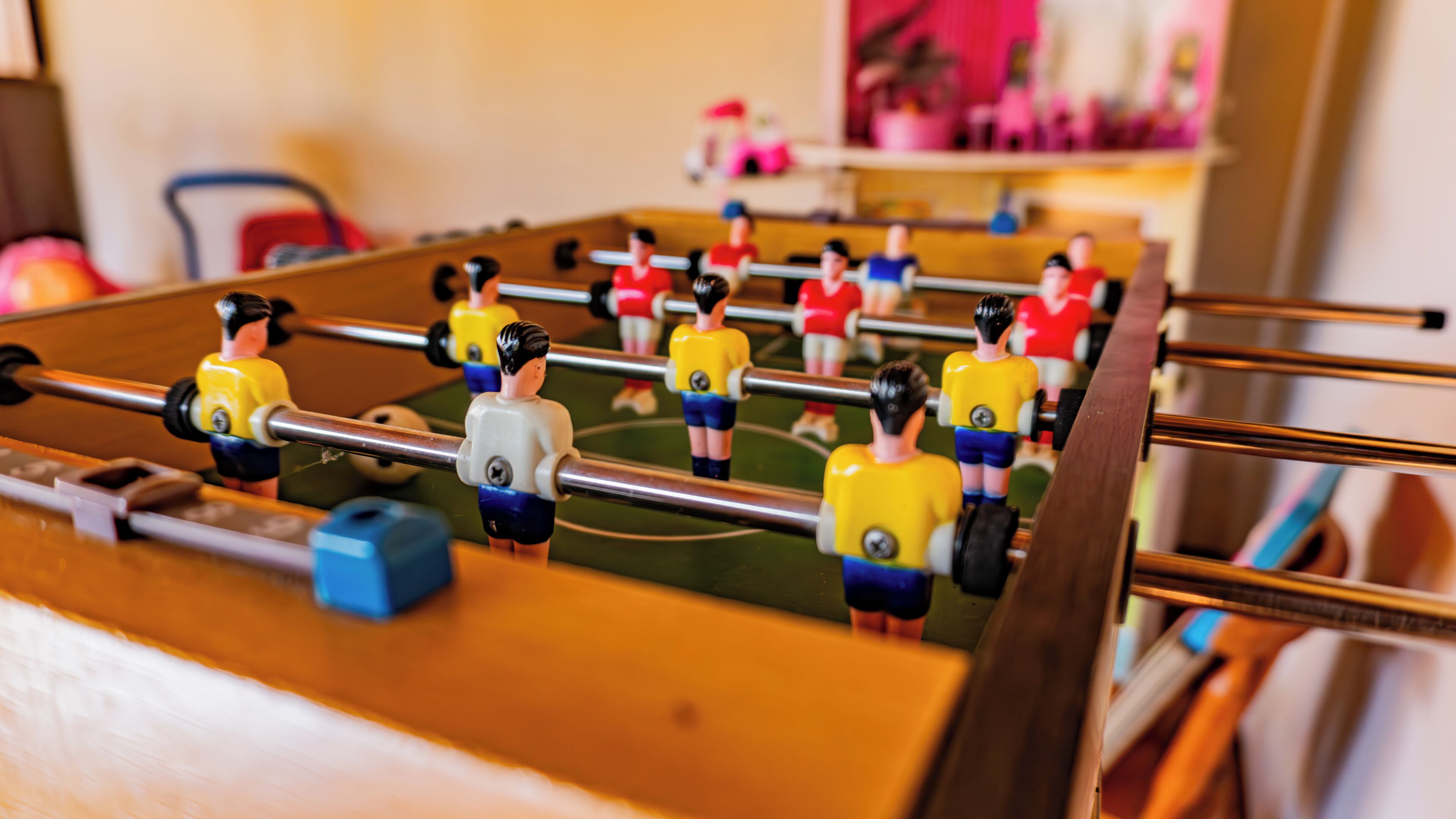 Una mesa de fútbol de mesa con jugadores con uniformes amarillos y rojos.