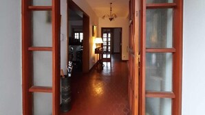 A hallway with a tiled floor leading to a room with a door.