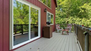 A covered deck with a wooden floor, a barbecue grill, and a table with chairs. - SHORT WALK TO A LARGE SANDY BEACH (FRYE ISLAND)