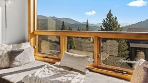 A room with a large window offering a mountain view. - Big Sky Ski in- Ski out retreat/ Freshly Remodeled (Big Sky)