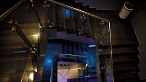 A modern staircase with glass railings and metal handrails, leading to an upper floor. - The Grand Plaza Hotel (Kampala)