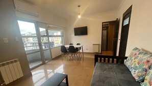 A living room with a sofa, a coffee table, and a dining area with chairs and a table. - Mirando el cerro (Salta)