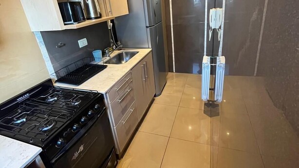 A modern kitchen with a gas stove, stainless steel refrigerator, and a sink. - Mirando el cerro (Salta)