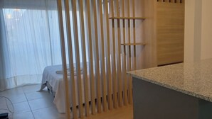 Ein Zimmer mit einem Bett, einer Holzwand und einer Arbeitsplatte aus Granit.