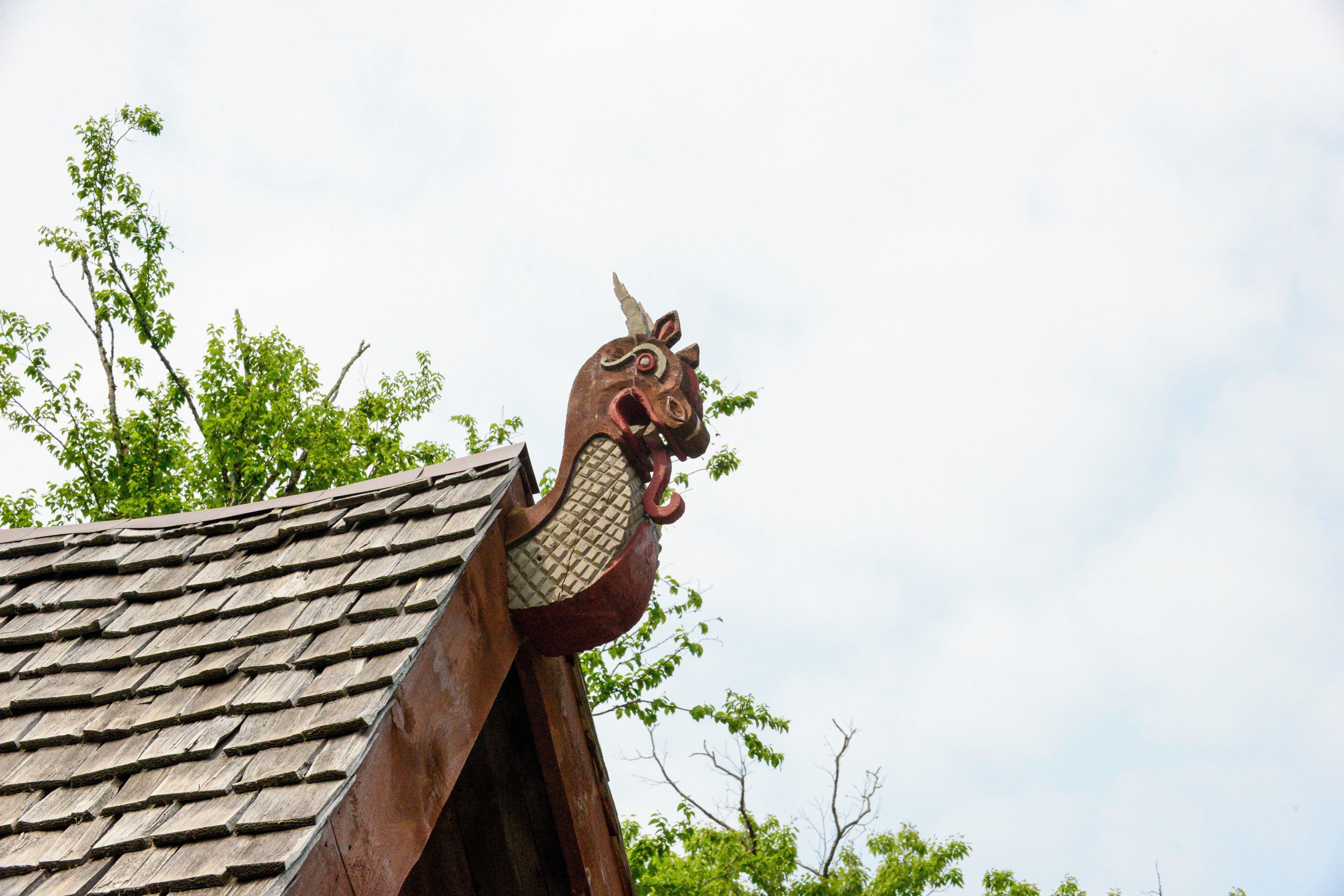 Ein traditionelles Dach mit einer verzierten Drachenfigur als Wetterfahne.