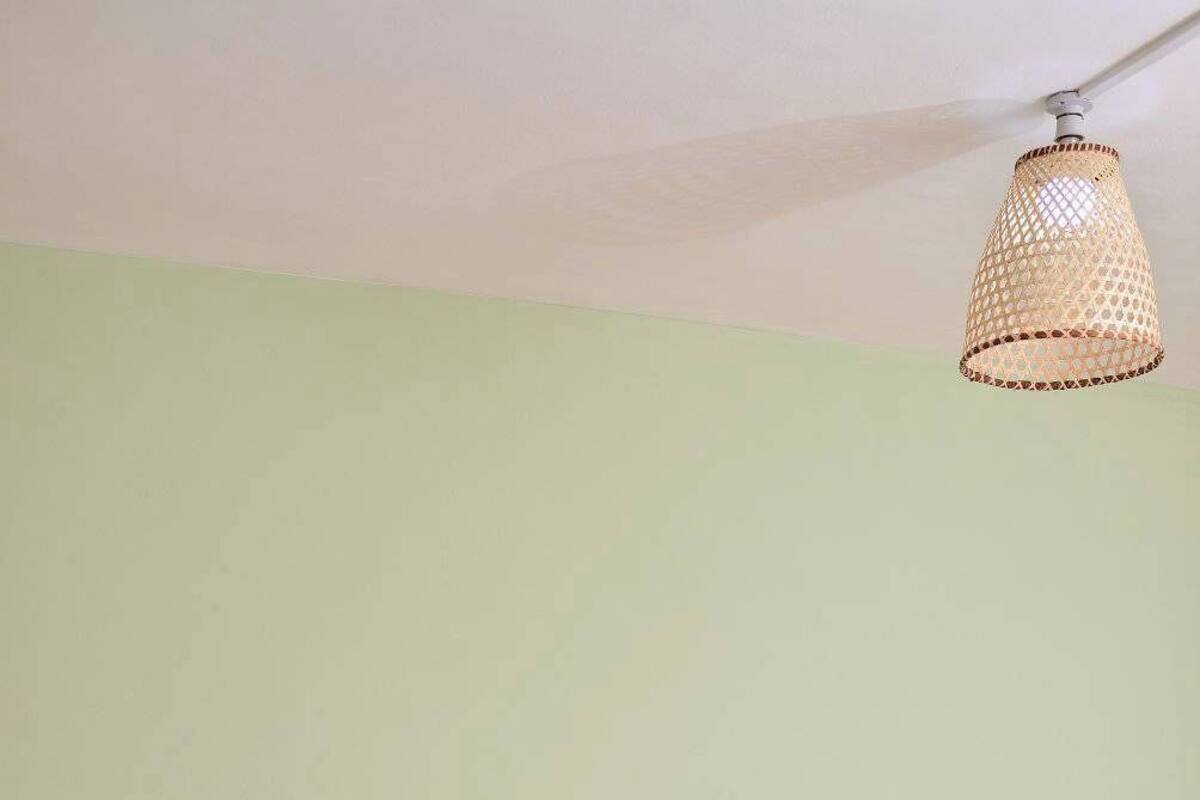 A bedroom with a bed, a nightstand, and a hanging light fixture.