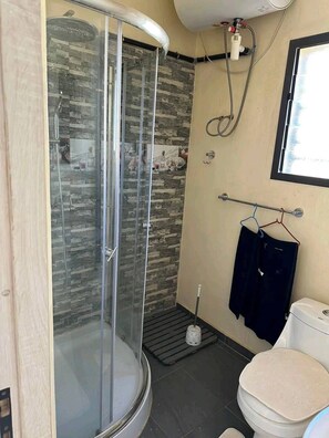 Een douche, handdoeken, zeep, shampoo
