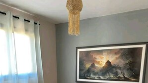 A bedroom with a bed, a painting, and a nightstand. - Auberge Iorenantsoa (Talata Volonondry)
