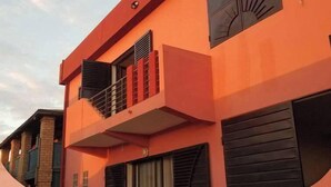 A modern building with a balcony and shutters. - Auberge Iorenantsoa (Talata Volonondry)