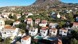 Un quartier résidentiel avec des maisons, une montagne en arrière-plan et une piscine.