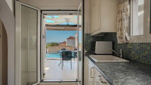 Une cuisine ouverte donnant sur une piscine et un espace salon extérieur.
