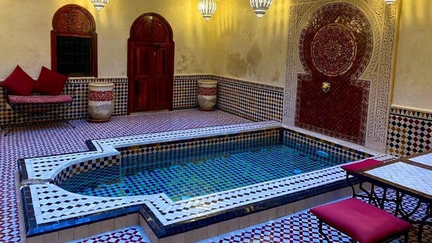 A luxurious indoor swimming pool with intricate tile work and traditional decor. - Riad Prada (Marrakech)
