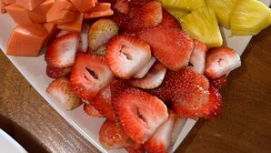 Una bandeja de frutas con diversas variedades, incluyendo sandía, piña, fresas y plátanos.