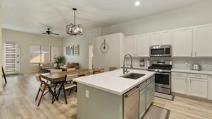 A modern kitchen with white cabinets, stainless steel appliances, and a central island. - Chandler Hideaway - Relax & Unwind | Heated pool (Chandler)