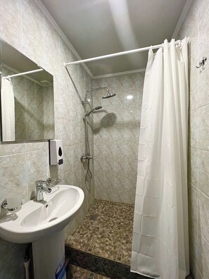 Eenpersoonskamer, privébadkamer, uitzicht op binnenplaats | Badkamer | Een douche, gratis toiletartikelen, een haardroger, pantoffels