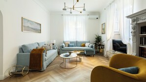 Un salon comprenant un canapé, un fauteuil, une table basse et une cheminée.