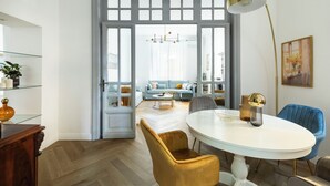 A dining area with a round table, chairs, and a pendant light. - Belle Epoque House of Mirror (Rome)