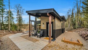 A modern lodge with a covered patio, outdoor seating, and a gravel path. - Tiny Cabin Getaway #6 @Unplug Resort, Sauna, Full Kitchen (Brian Head)