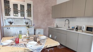 Une cuisine équipée d’une table à manger pour quatre personnes, d’un réfrigérateur, d’un four à micro-ondes et d’un évier.