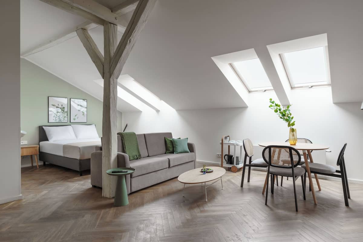 Uma sala de estar no estilo loft, com sofá, mesa de centro e área de refeições.