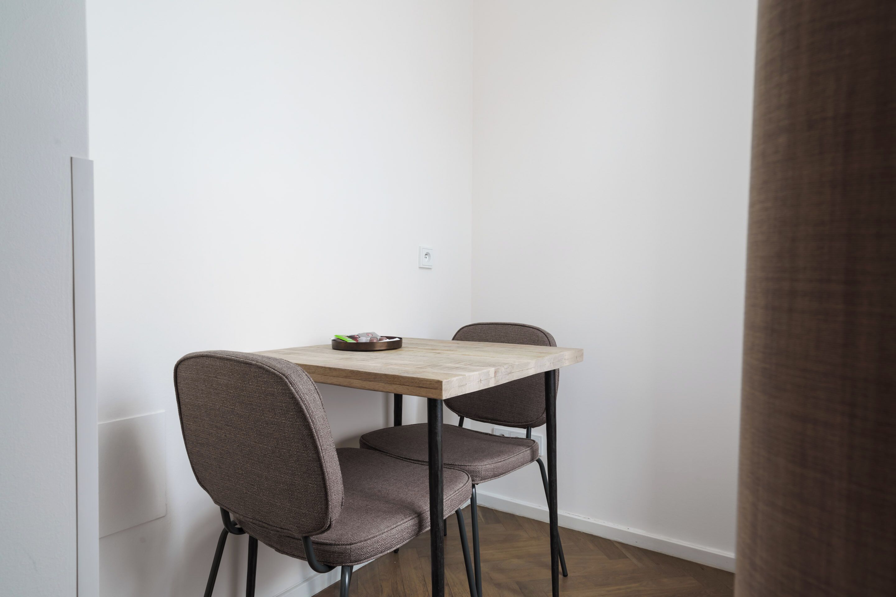 Un pequeño comedor con una mesa de madera y dos sillas.
